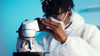 A lab student using a microscope.